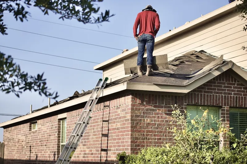 Professional roofer working on a residential roof in Manor Village